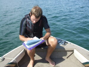 A person taking notes on a boat.