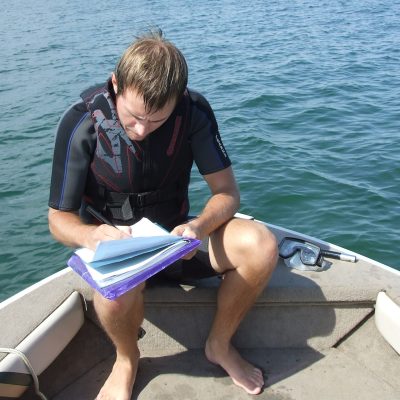A person taking notes on a boat.